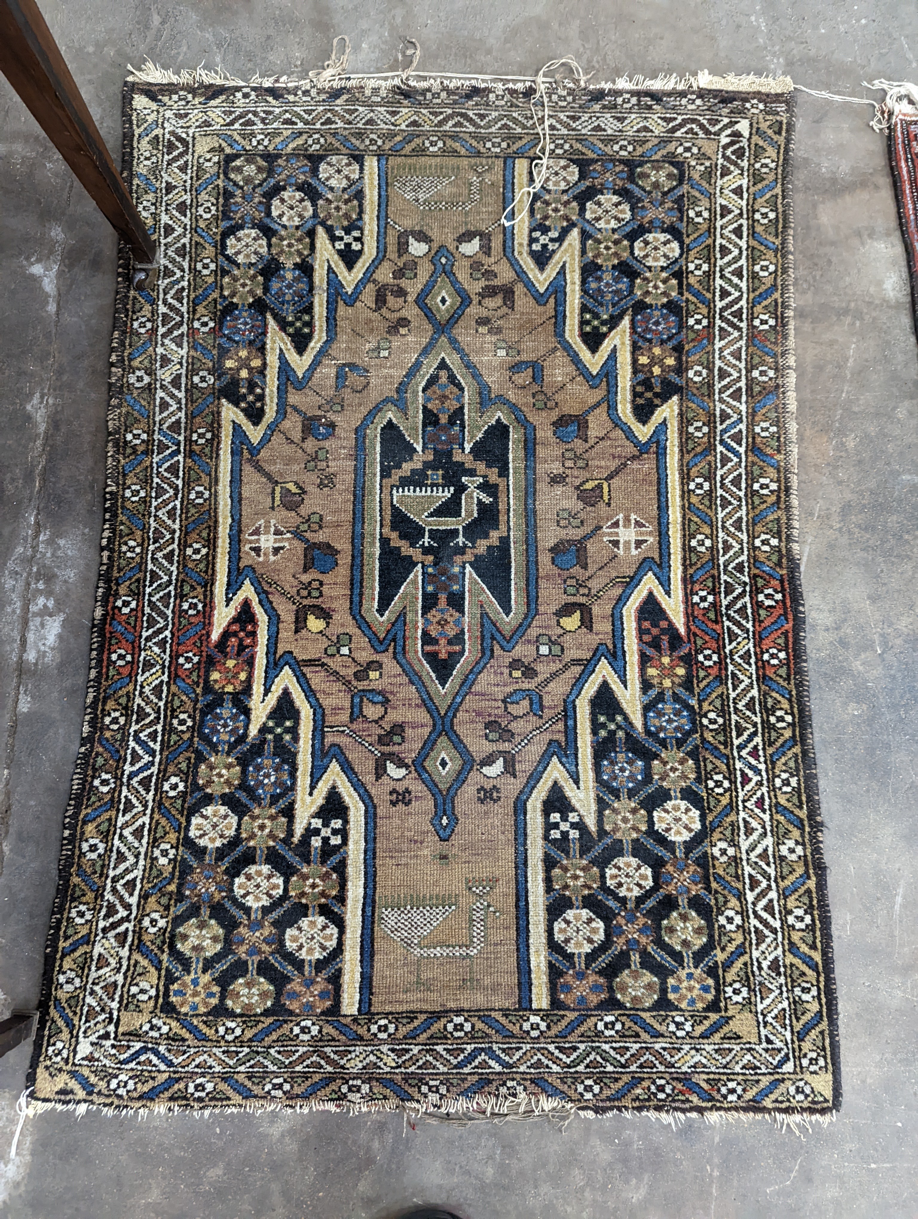 A Caucasian tribal rug, woven with a geometric medallion and stylised deer, 118 x 80cm